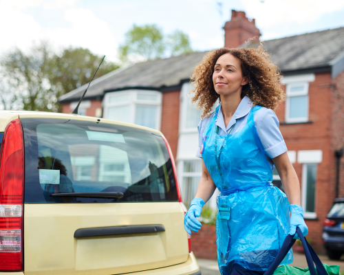 home carer walking from her car to a client's home