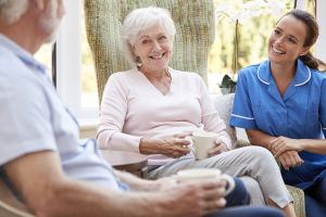 man and woman with nurse having a cup of tea